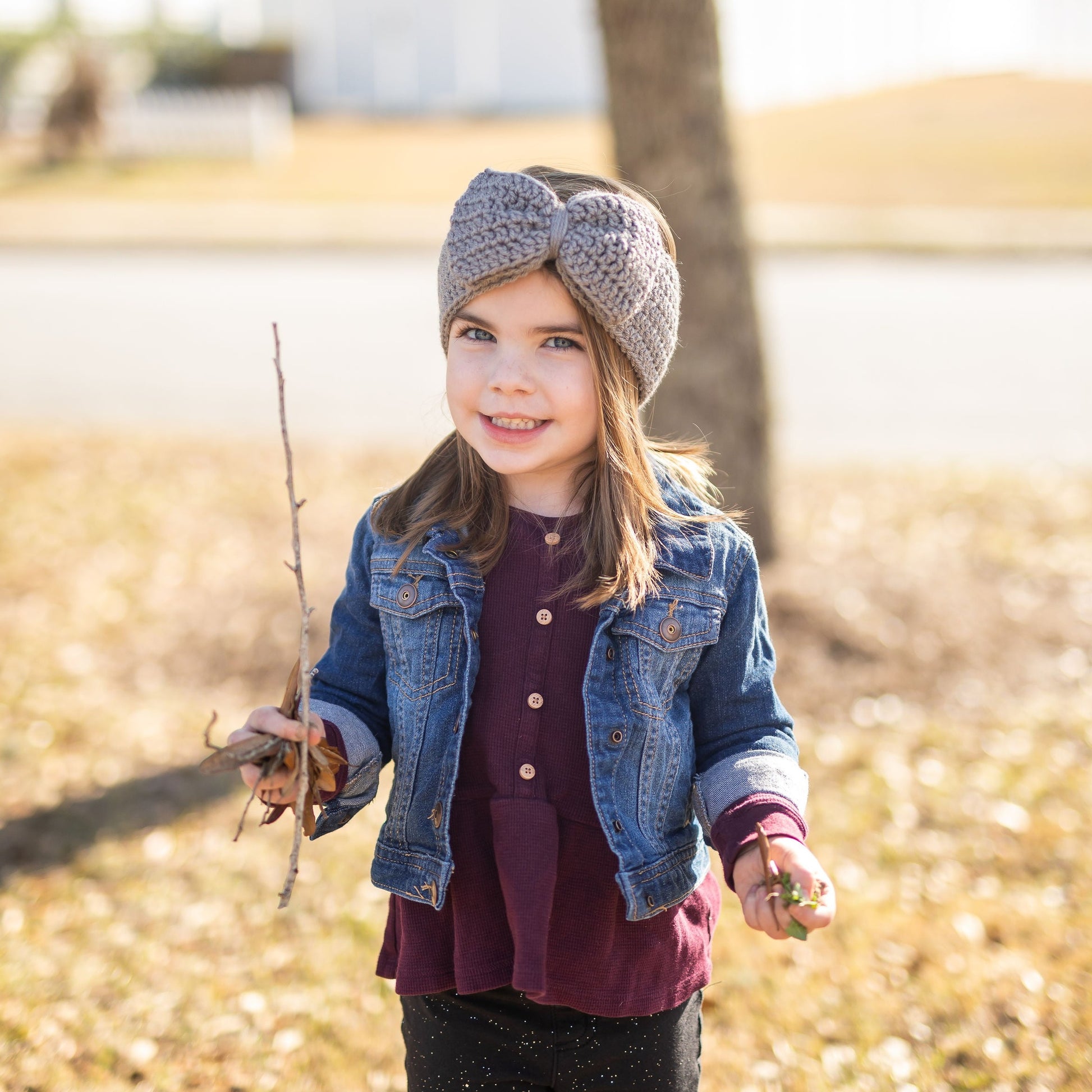girl wearing a grey big bow ear warmer headband