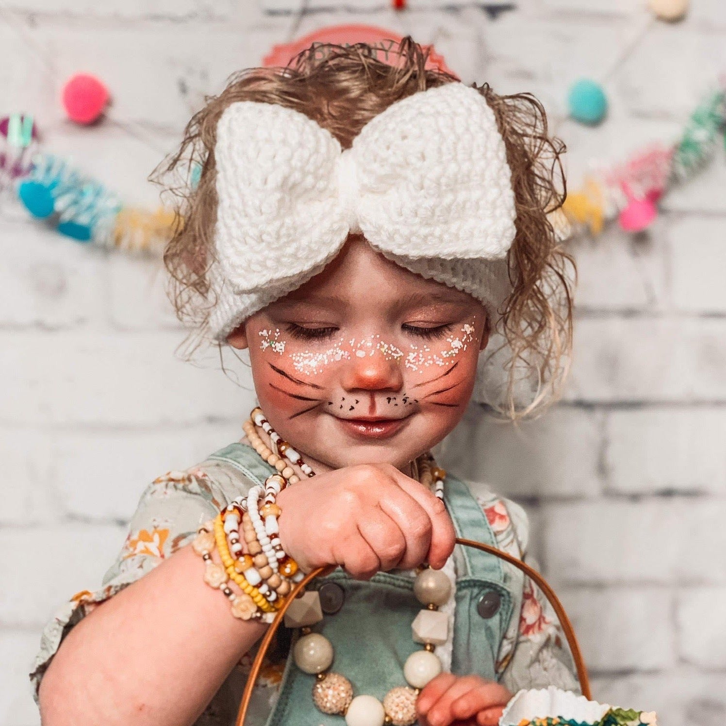 girl wearing white big bow ear warmer headband