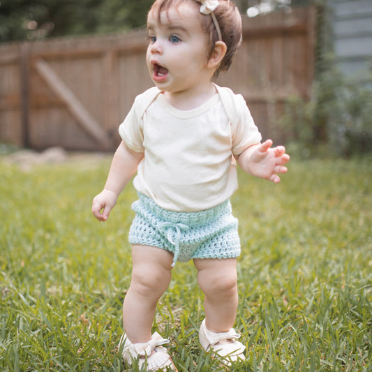 baby playing in light blue crochet shorts