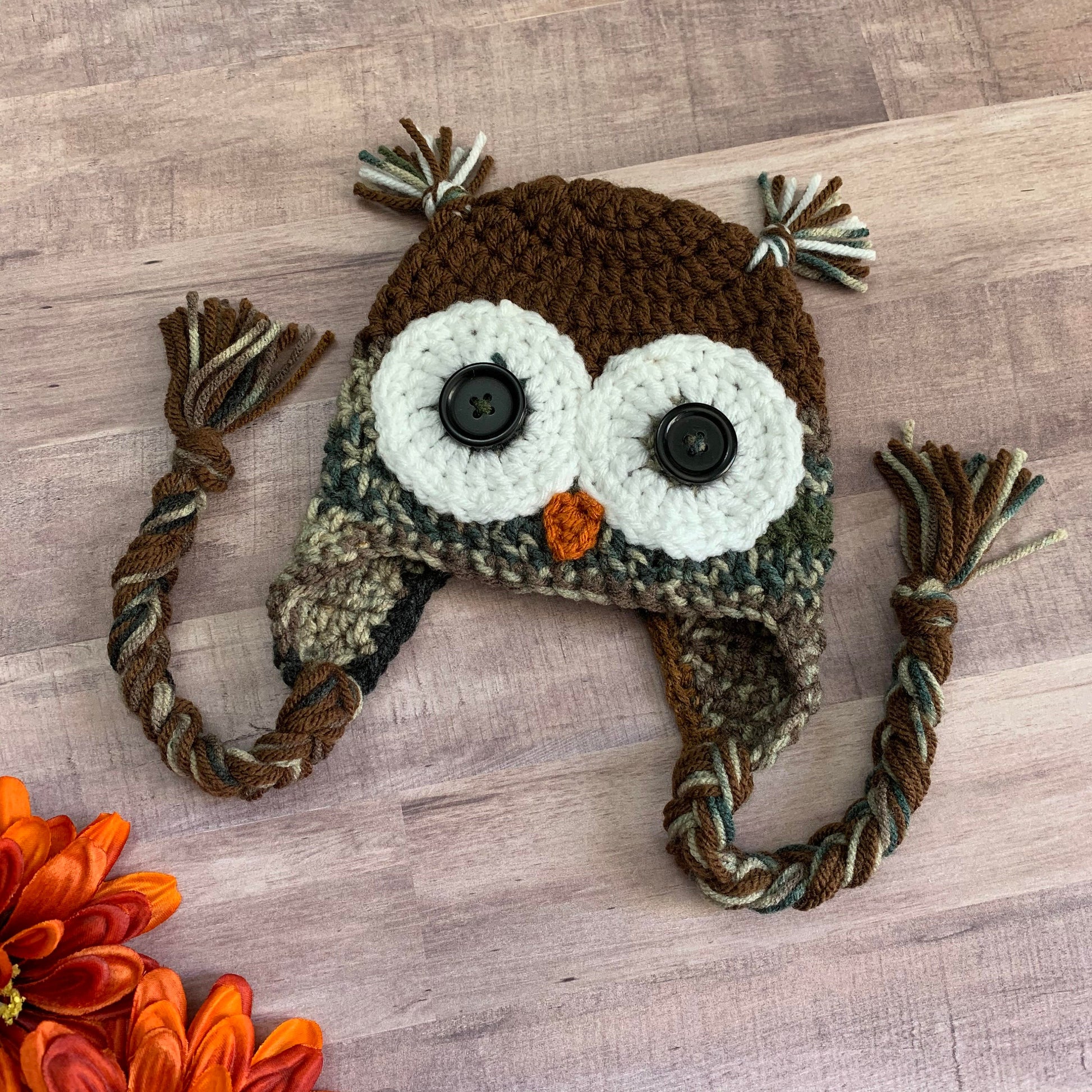 camouflage owl beanie flat lay on a wooden background