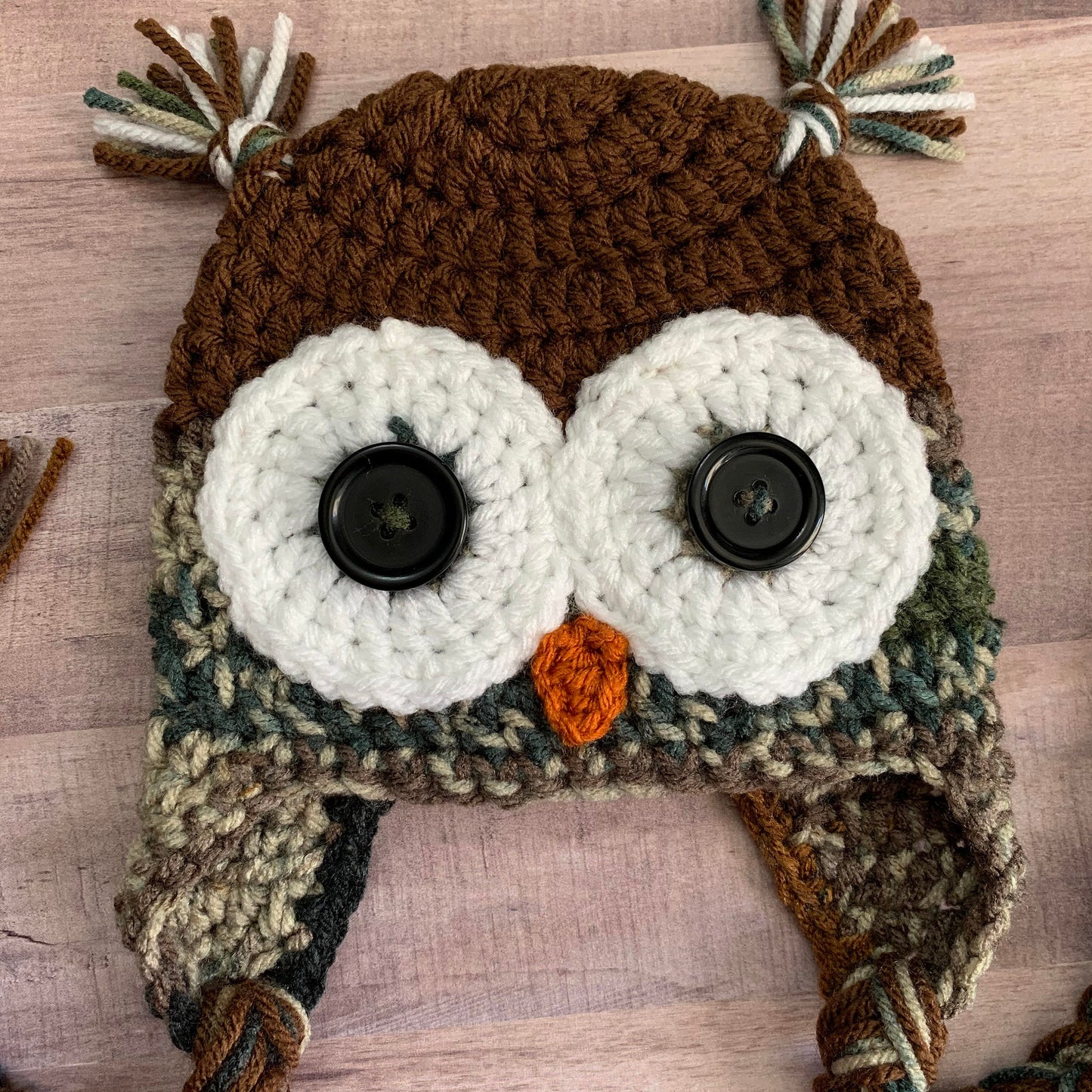 close up of the owl face on a camouflage theme owl beanie