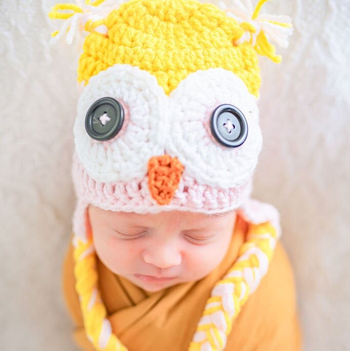 close up of the owl eyes on this yellow and pink owl beanie