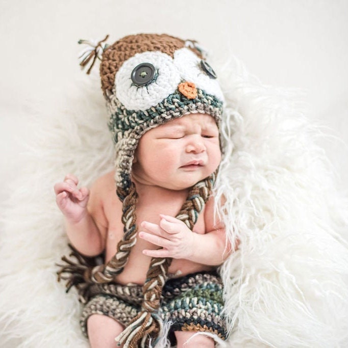 Newborn wearing a camouflage owl beanie