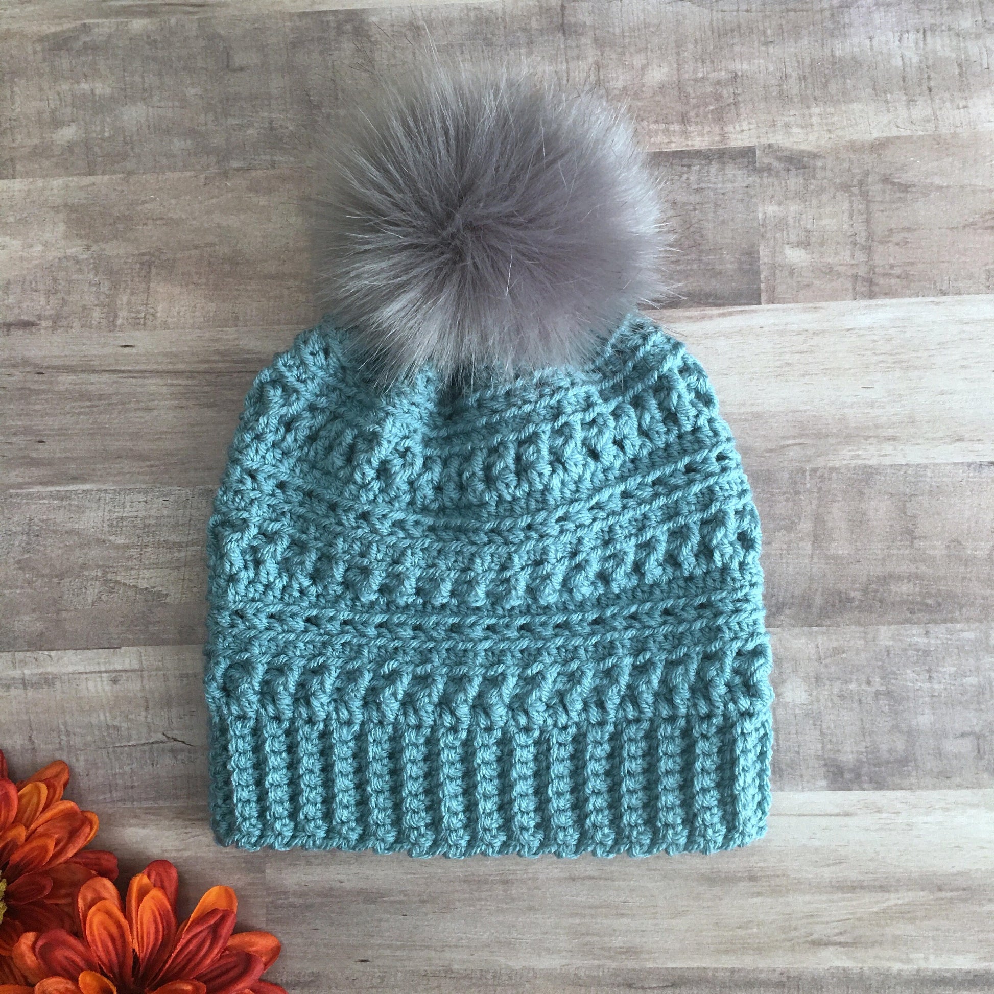 Blue textured beanie with faux fur pom pom