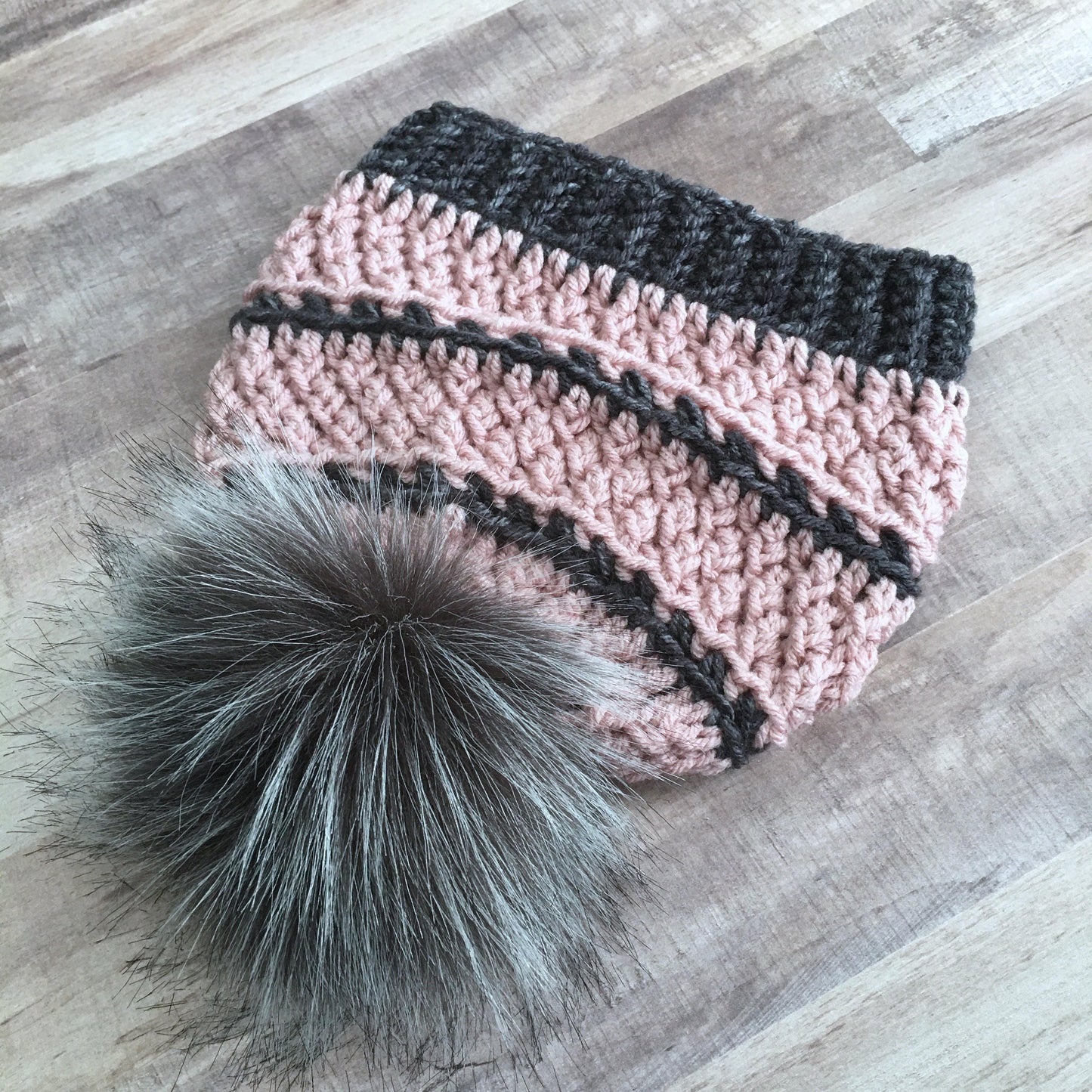 Grey and blush textured beanie with a grey faux fur pom pom