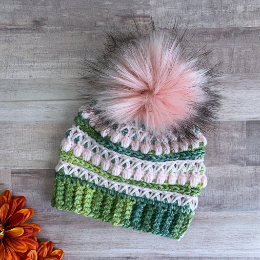 Green and pink beanie with pink faux fur pom pom