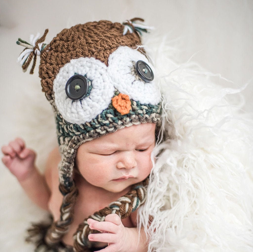 Newborn wearing a camouflage owl beanie