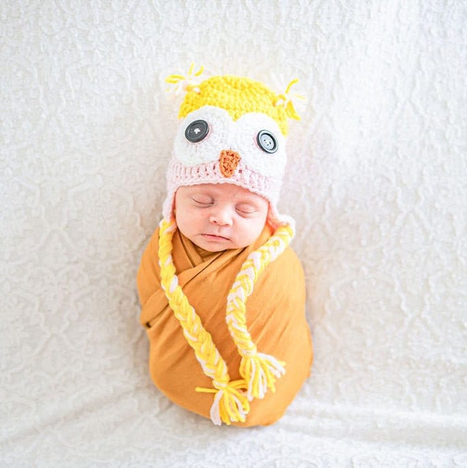 Newborn in a yellow and pink owl beanie