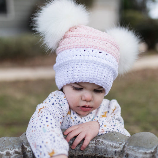 White and pink beanie with two white faux fur pom poms