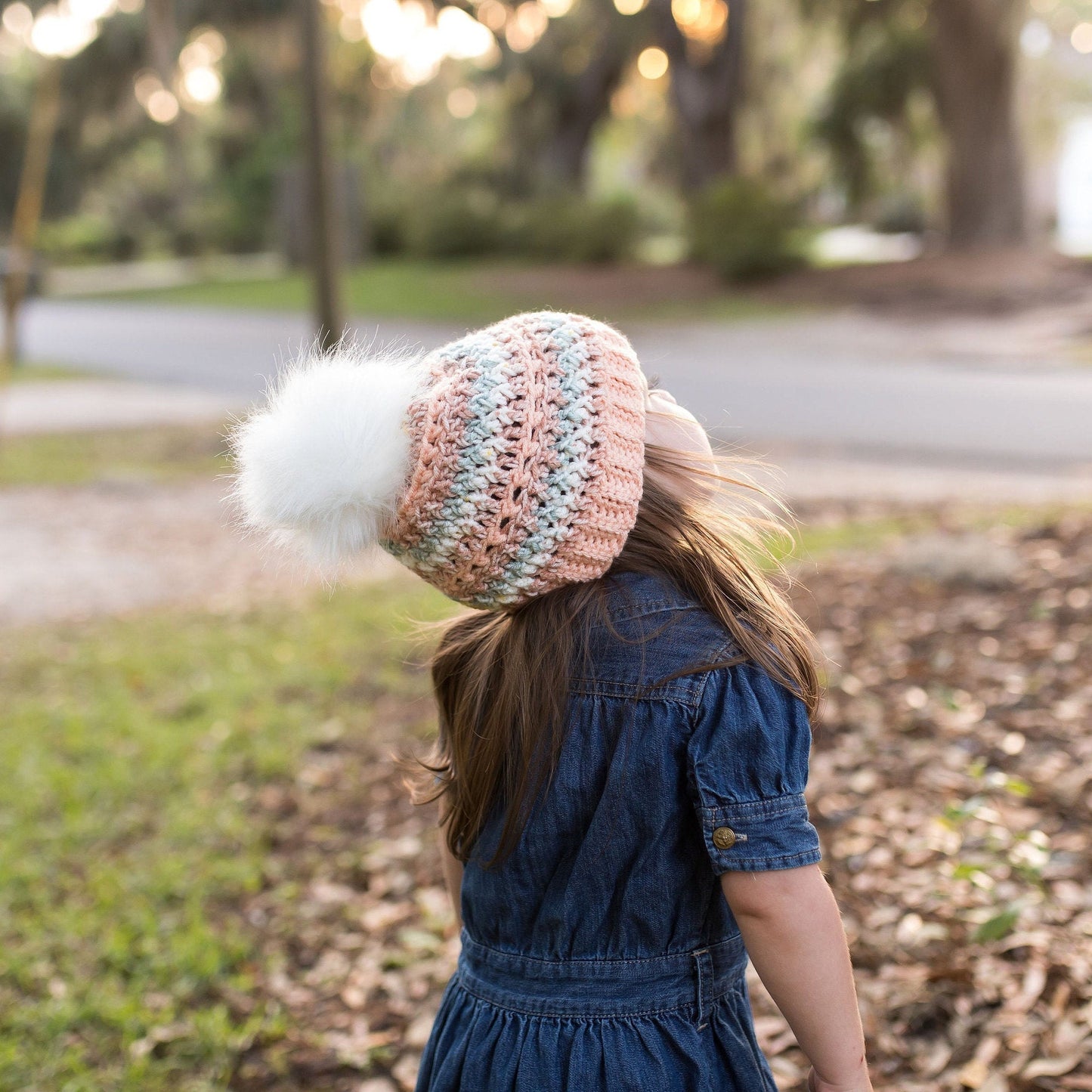 Colorful peach beanie with a white faux fur pom pom