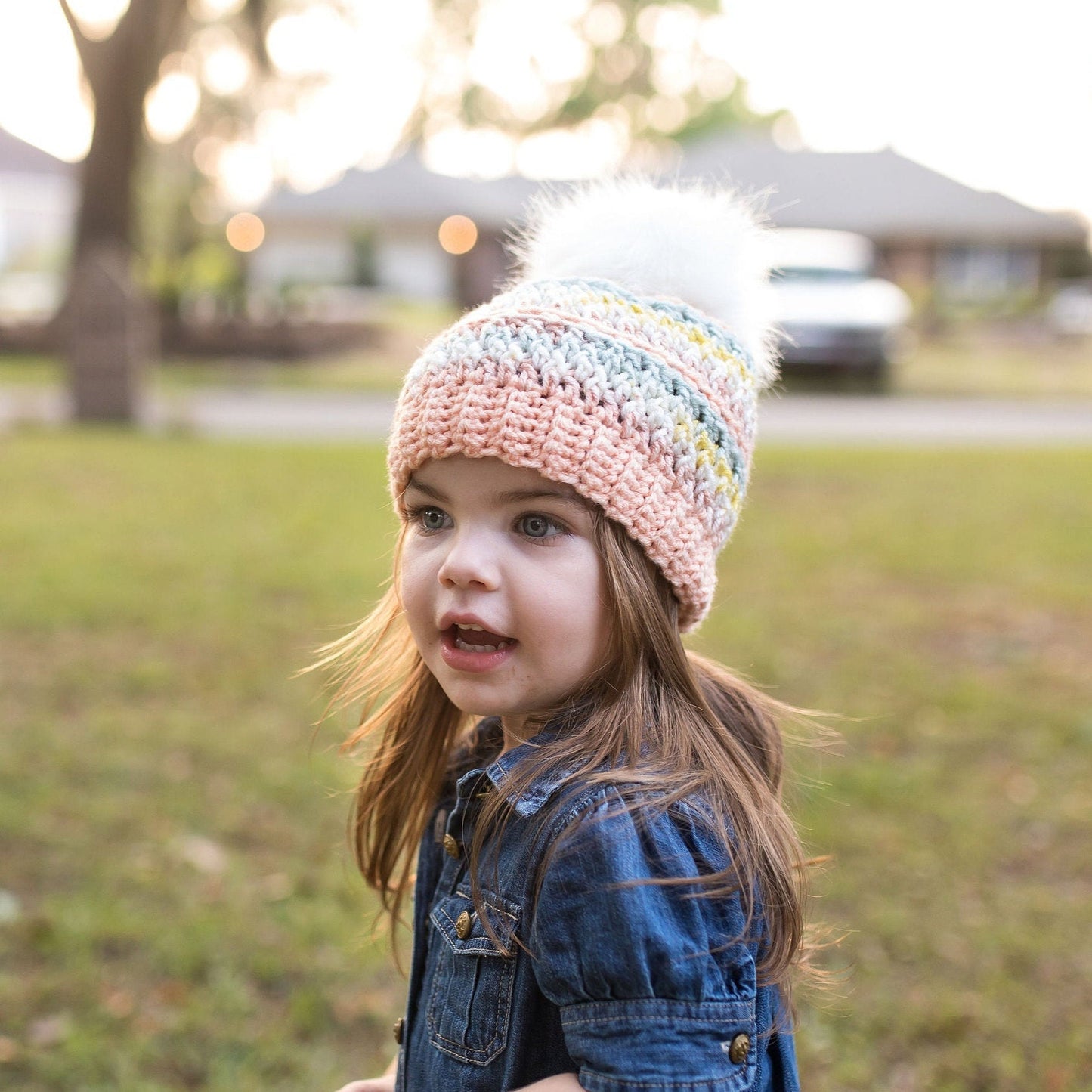 Colorful peach beanie with a white faux fur pom pom