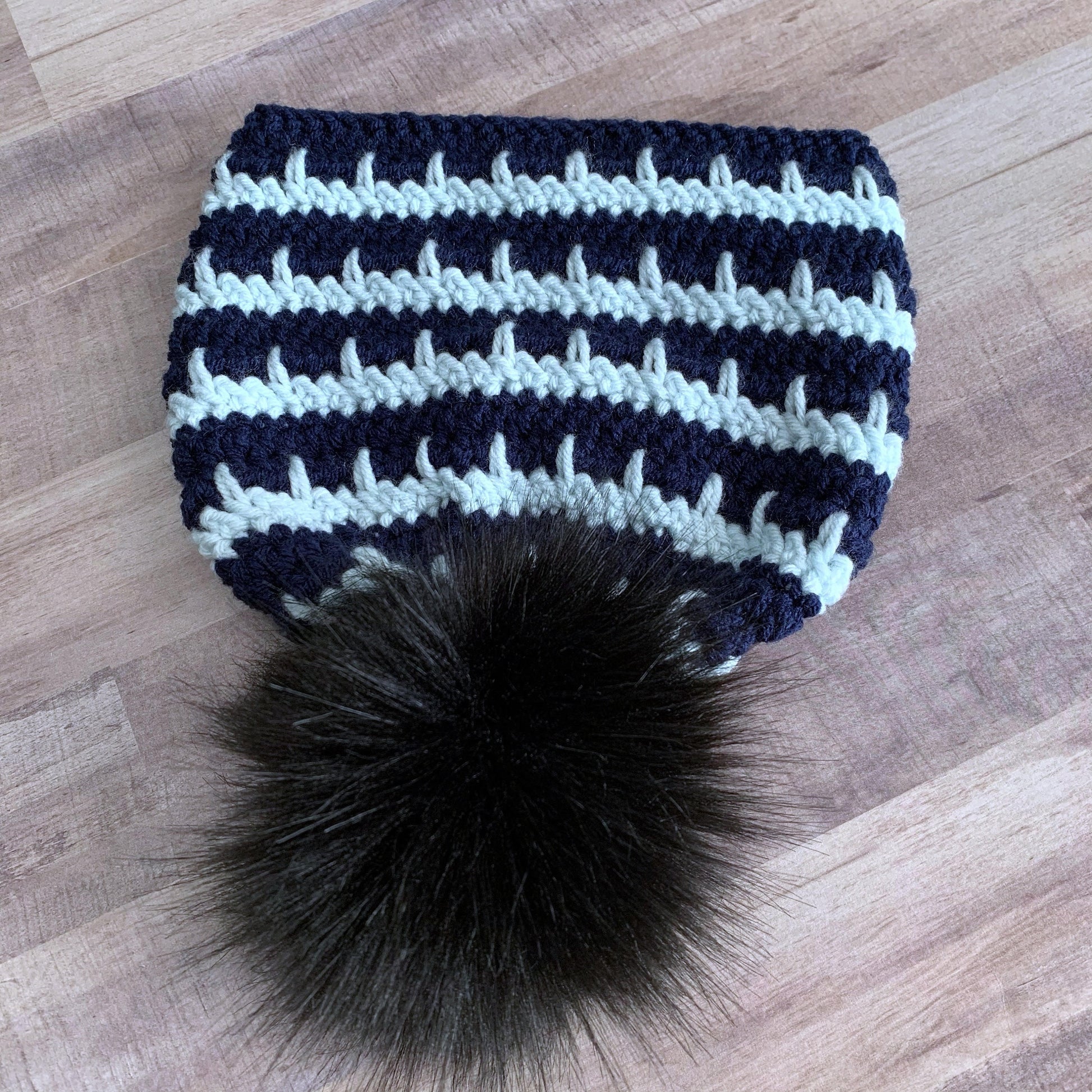 Full view of the black pom pom on this beanie