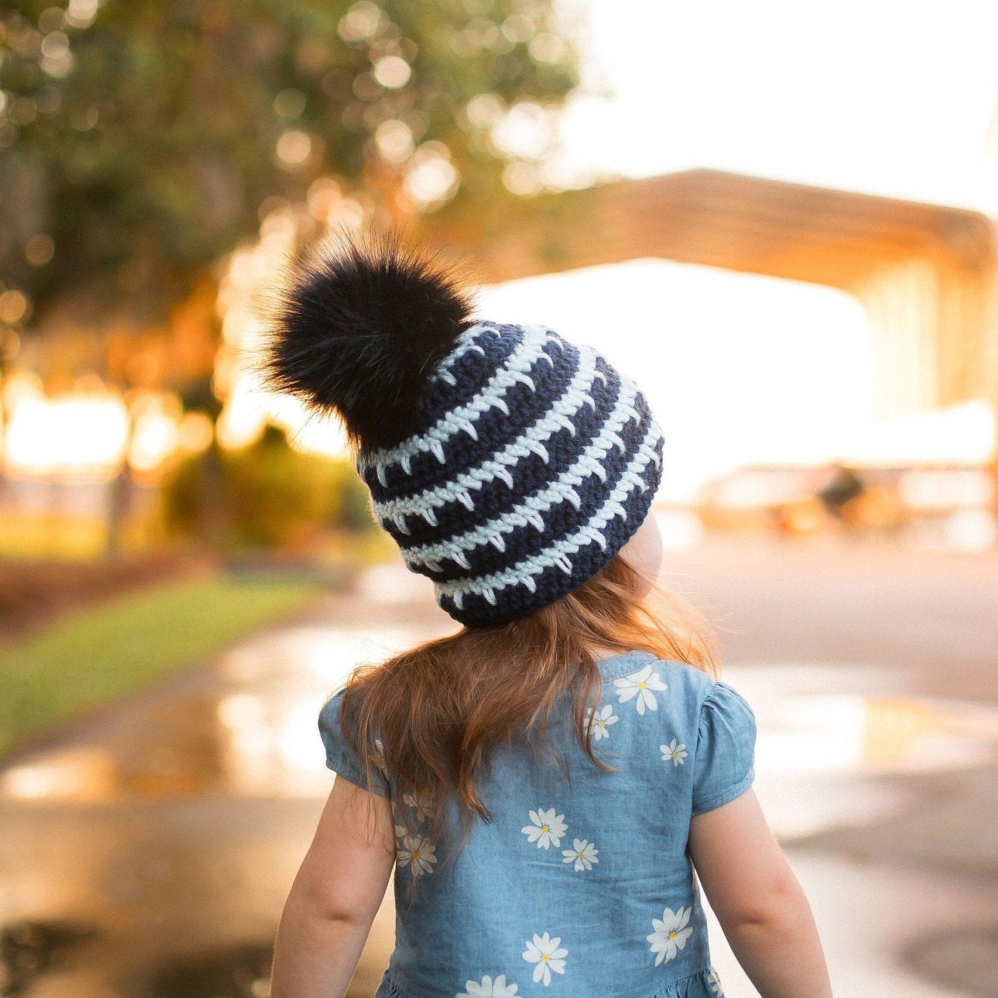 Back view of the navy and arctic ice striped beanie with a black pom pom