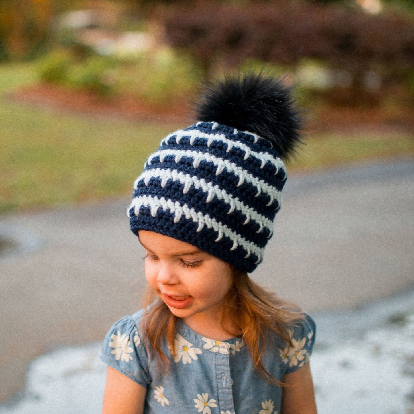 Navy and arctic ice striped beanie with a black pom pom