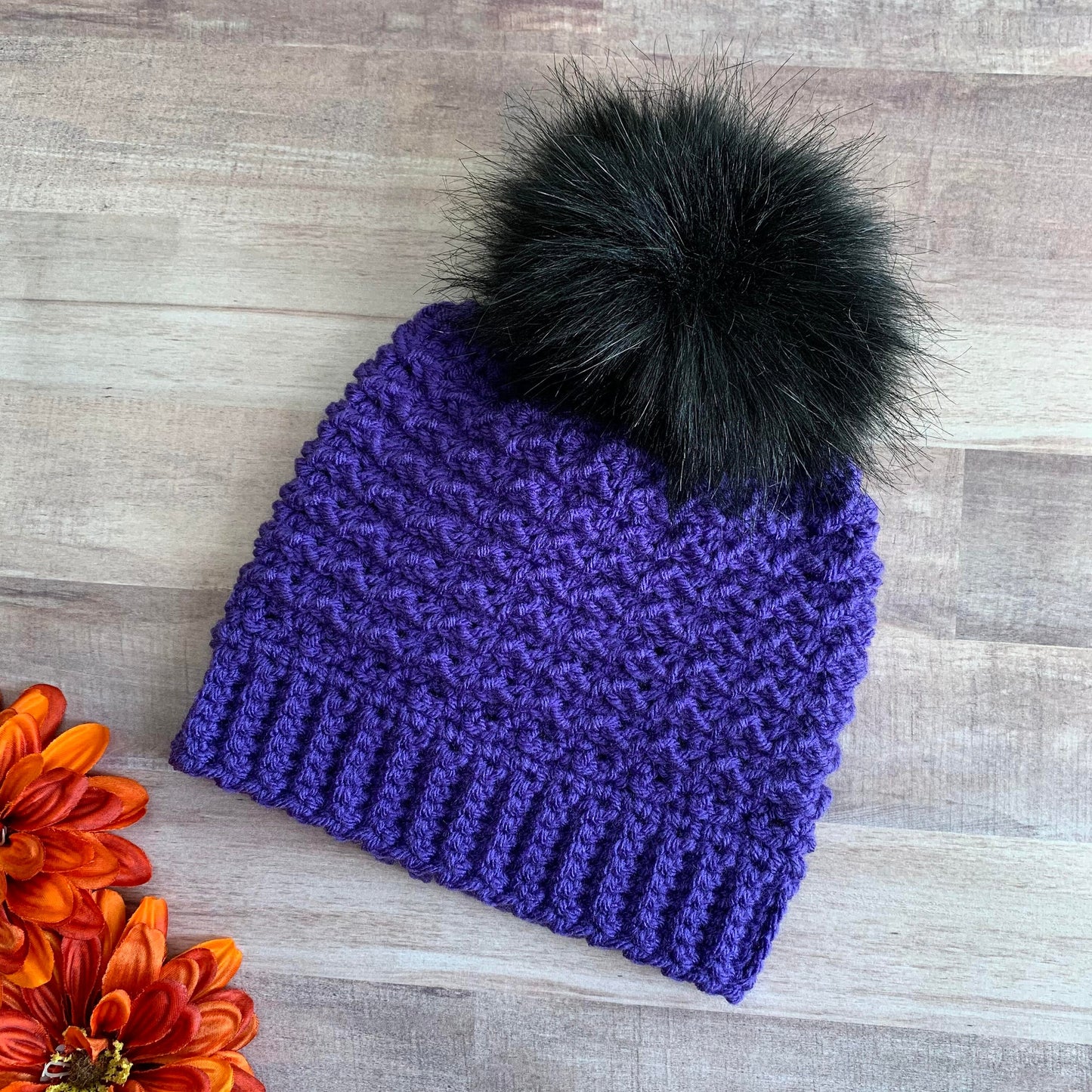 Purple beanie with black pom pom