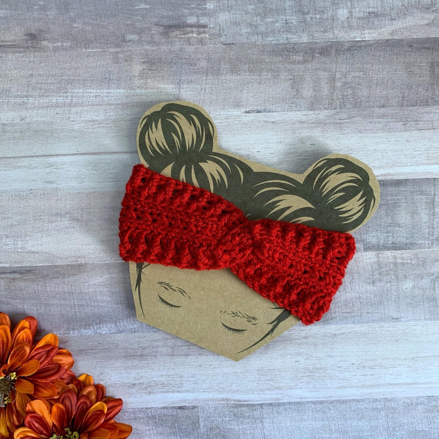 Red twisted headwrap ear warmer flat lay on a wooden background