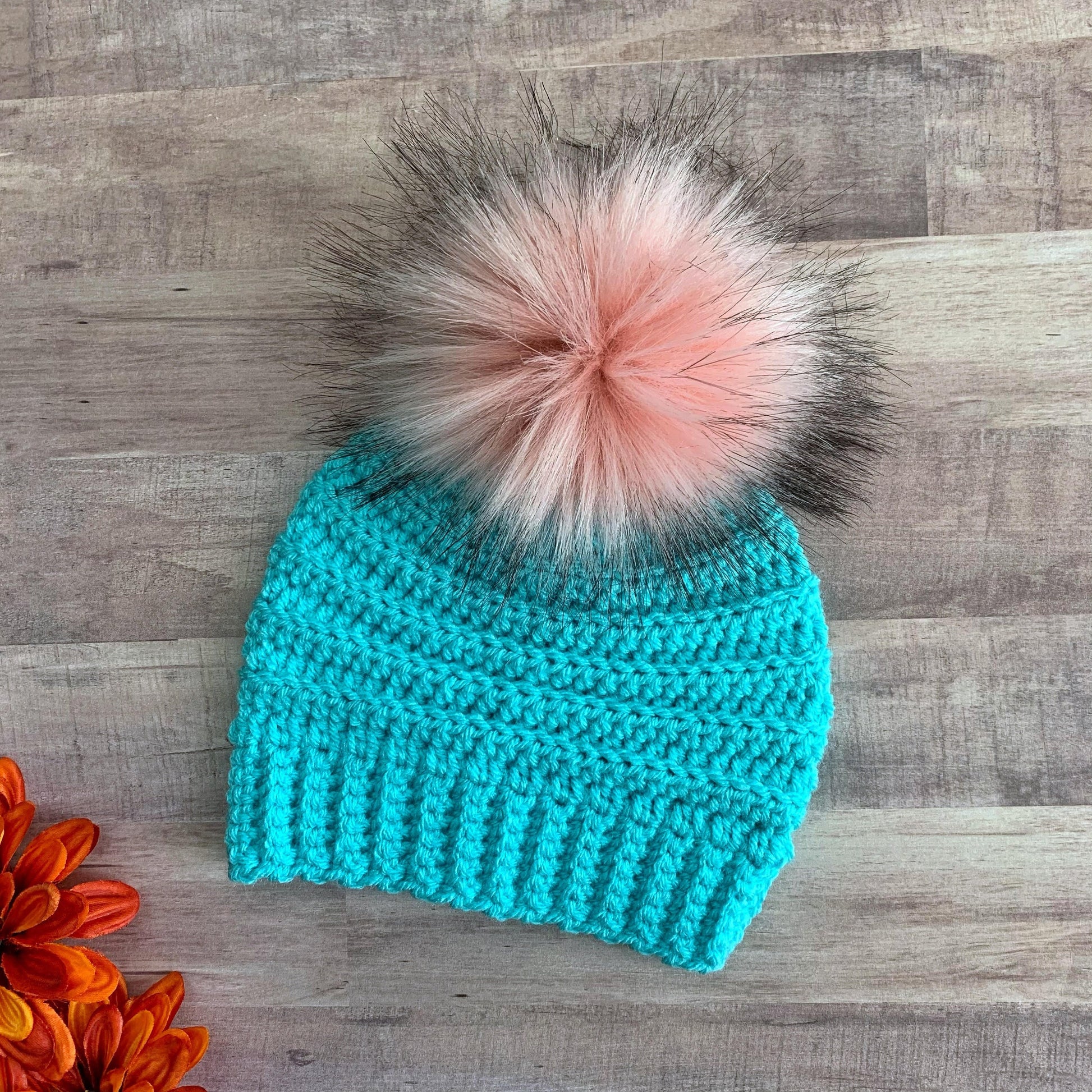 Blue beanie with pink faux fur pom pom