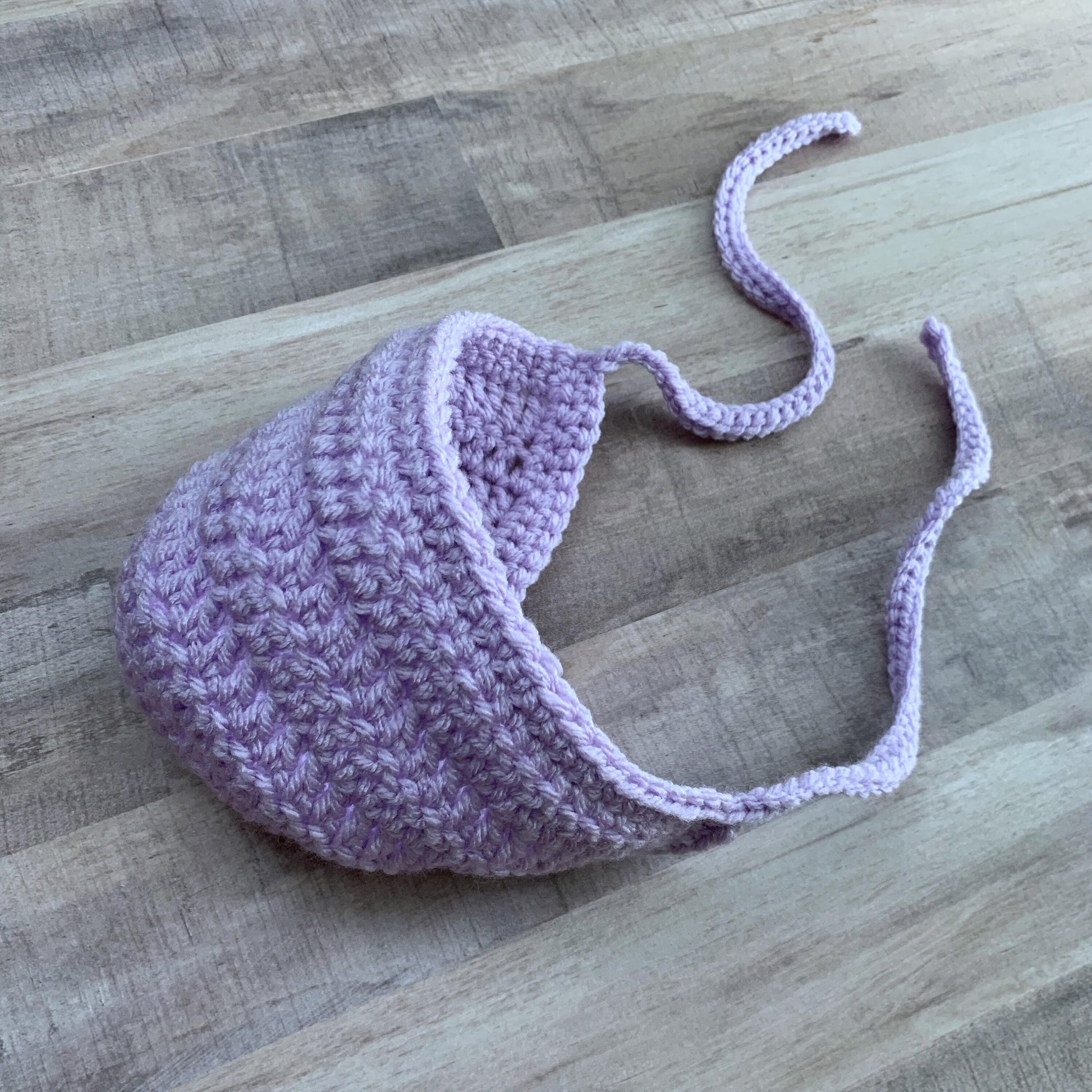 lavender bonnet flat lay on a wood background