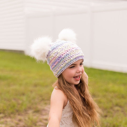 Pastel beanie with two white faux fur pom poms