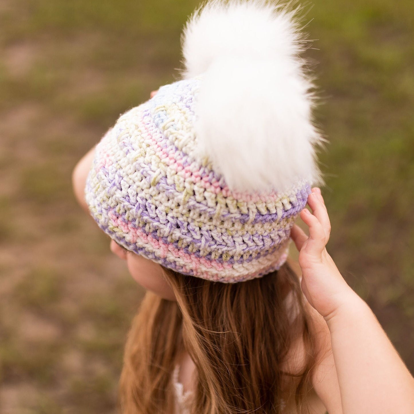 Pastel beanie with two white faux fur pom poms