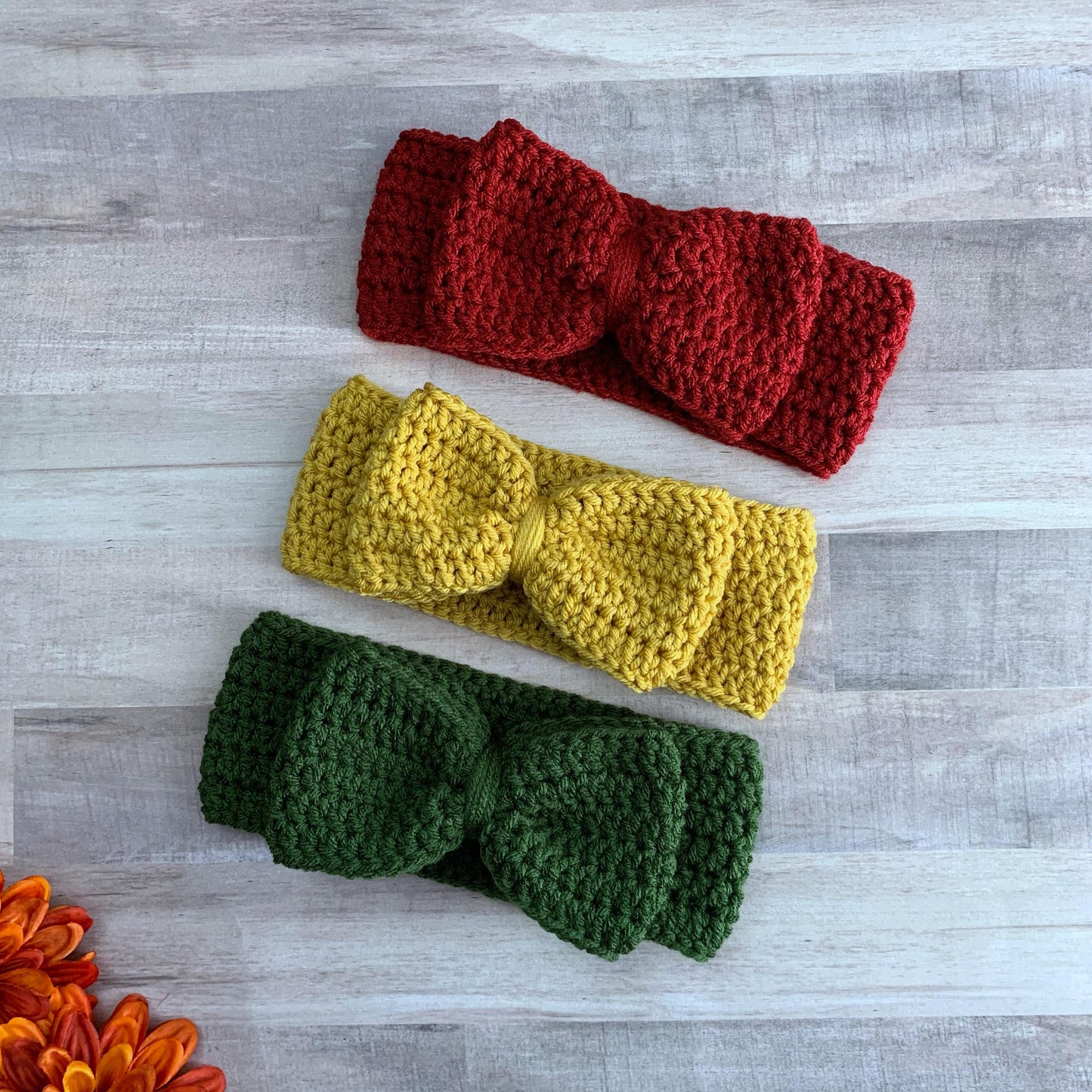 Burgundy, mustard yellow and olive green big bow headbands on a wooden background