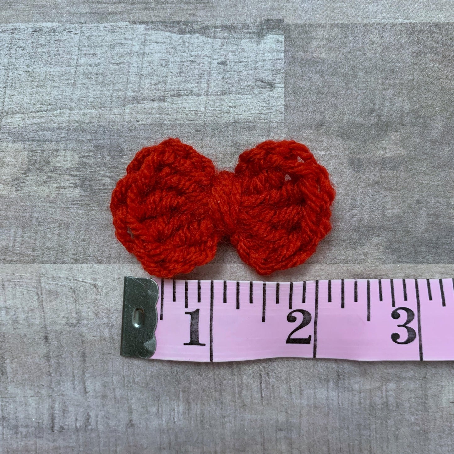 Picture of the 2" bow against a tape measure to show size