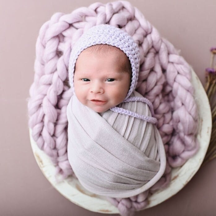 newborn in a lavender bonnet